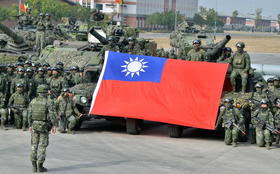 Members of Taiwan’s 564th Armored Brigade hold their flag after demonstrating their ability to repel an airborne attack near Kaohsiung, Taiwan, Jan. 11, 2023. 