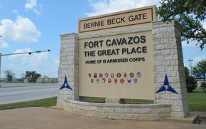 A stone welcome sign reads “Bernie Beck Gate Fort Cavazos” next to a road.