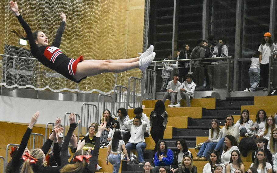 American Overseas School of Rome cheerleaders prepare to catch Reiley Elizabeth Lester after a throw during the 2024 DODEA-Europe Cheerleading Championships in Wiesbaden, Germany on Friday, Feb. 16, 2024. 