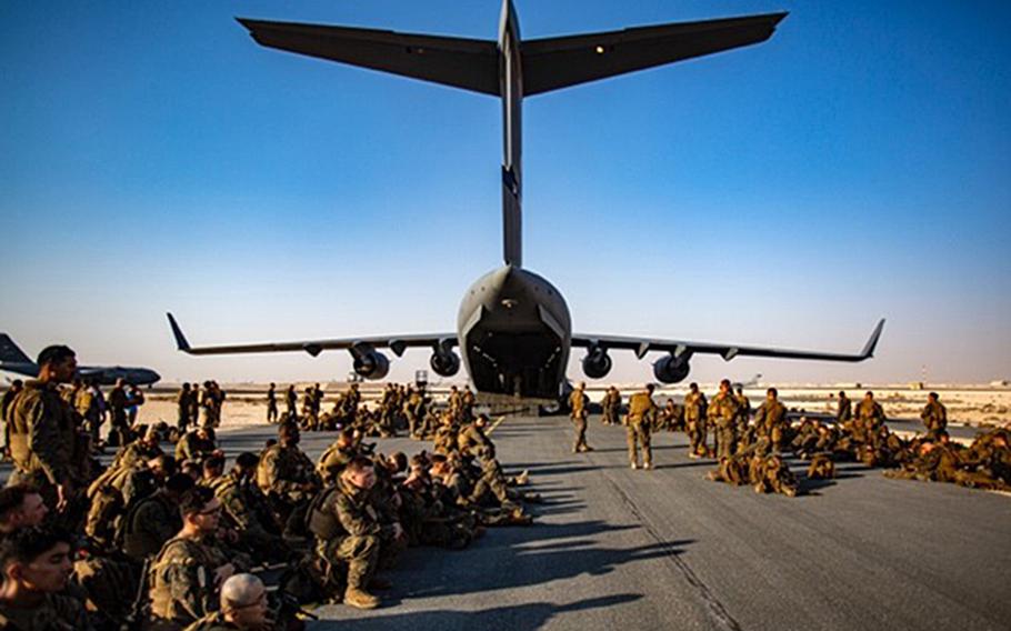 Marines assigned to the 24th Marine Expeditionary Unit await a flight at Al Udeid Air Base, Qatar, Aug. 17, 2021. Personnel at the base are working to airlift and house people arriving from Afghanistan.