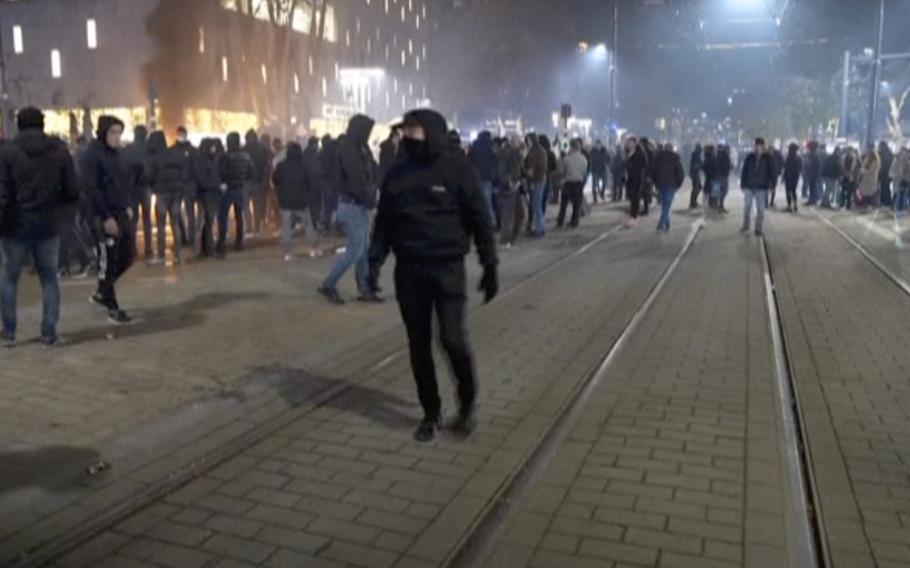 In this image taken from video, demonstrators protest against government restrictions due to the coronavirus pandemic, Friday, Nov. 19, 2021, in Rotterdam, Netherlands.