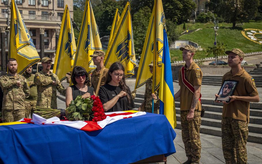 Relatives and soldiers of the Azov Regiment pay last respect near the coffin of their comrade.