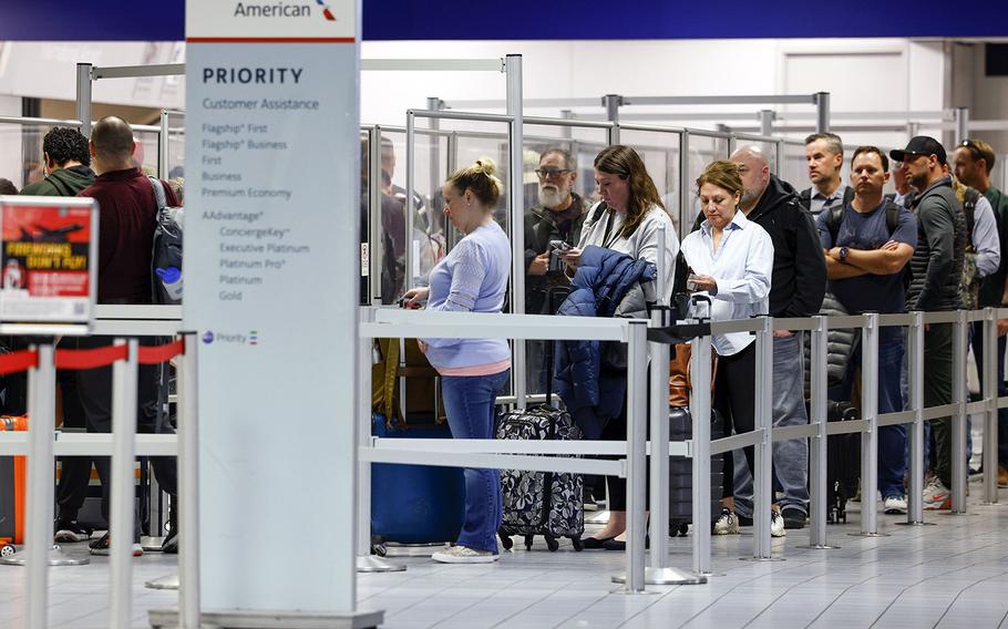 Passengers wait in line at a TSA security checkpoint inside Terminal C at DFW International Airport, on March 1, 2023. 