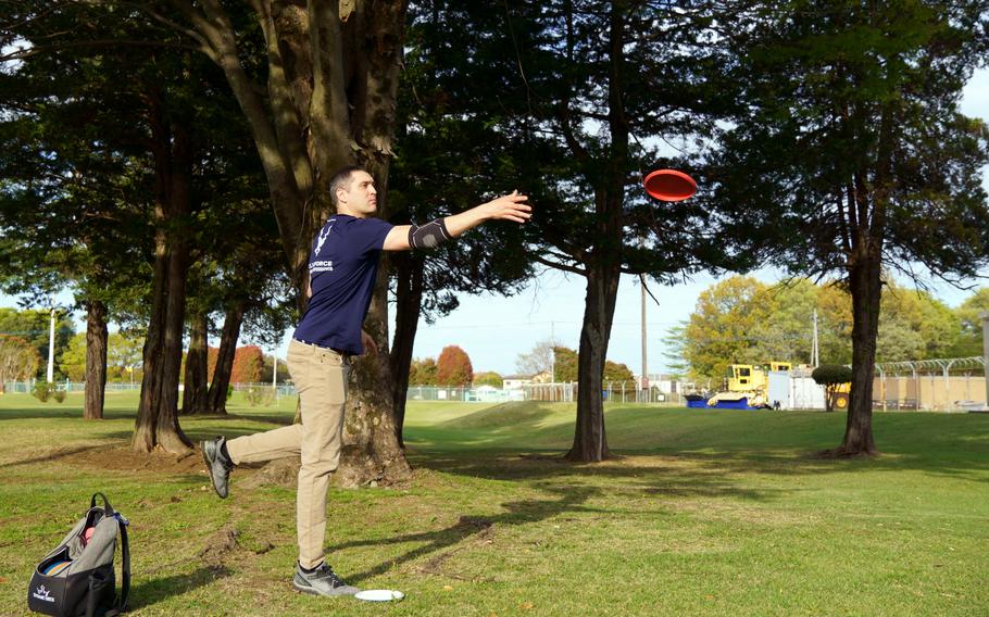 Air Force Maj. Marshall Gries makes a disc-golf tee shot on the Par 3 course at Yokota Air Base, Japan, April 6, 2023.