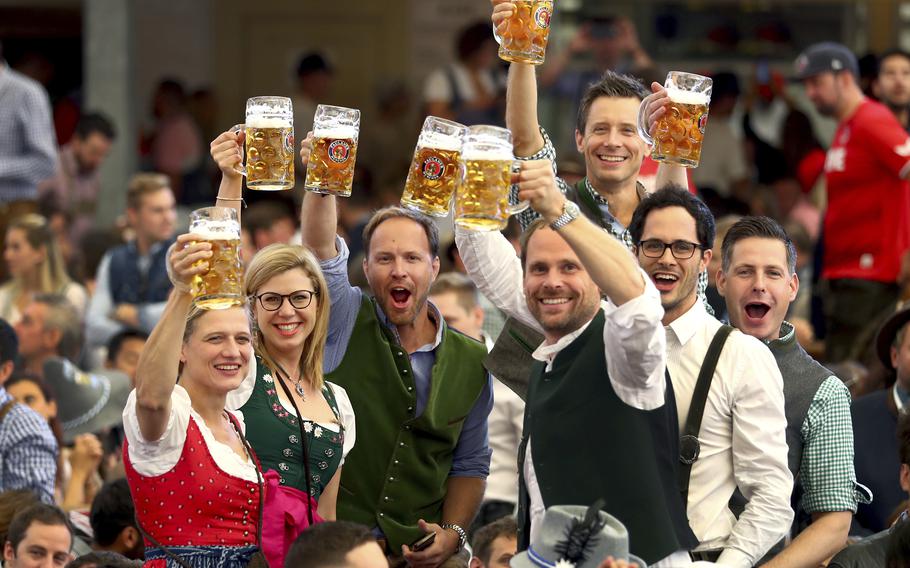 Visitors lift glasses of beer during the opening of the 186th ‘Oktoberfest’ beer festival in Munich, Germany, on Sept. 21, 2019. The beer will be just as cold and the pork knuckle just as juicy. But brewers and visitors are under pressure from inflation in ways they could hardly imagine in 2019. 