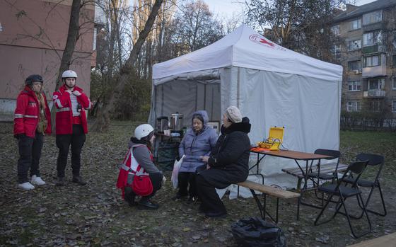 Paramedics give psychological aid to residents of a damaged apartment building following a Russian drone attack in Kyiv, Ukraine, Saturday, Nov. 25, 2023. Russia launched its most intense drone attack on Ukraine since the beginning of its full-scale invasion on Saturday morning, military officials said. (AP Photo/Efrem Lukatsky)