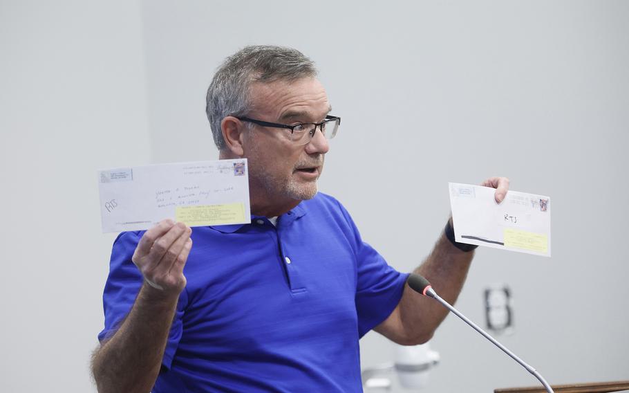 Cobb County, Georgia, resident Eugene Williams on Oct. 10, 2022, holds up envelopes he mailed to addresses that he says are invalid. 