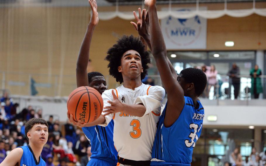 Spangdahlem’s Robert Leggett gets through the Hohenfels defense of Jacob and Joel Idowu in the Sentinels 65-63 win in the boys Division III final at the DODEA-Europe basketball championships in Wiesbaden, Germany, Feb. 17, 2024. 