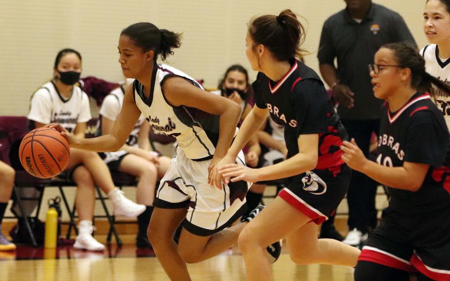 Matthew C. Perry's Breaunna Hayes dribbles upcourt alongside E.J. King's Aileen FitzGerald and Angela Romero during Friday's DODEA-Japan basketball game. The Cobras won 49-13.