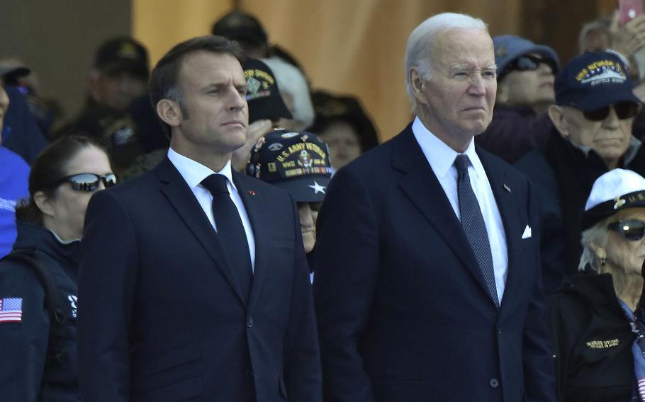 President Joe Biden and French President Emmanuel Macron stand for their official arrival during the D-Day 80th anniversary commemoration at Normandy American Cemetery in Colleville-sur-Mer, France, June 6, 2024.