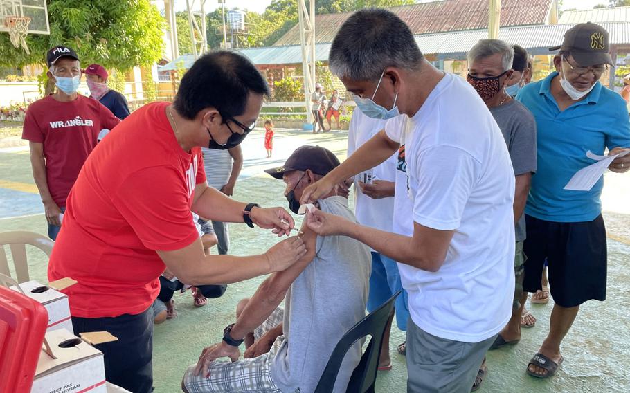 A member of the public receives a dose of the Covid-19 vaccine at a temporary vaccination site in San Salvador, Philippines, on Jan. 11. MUST CREDIT: Bloomberg photo by Andreo Calonzo