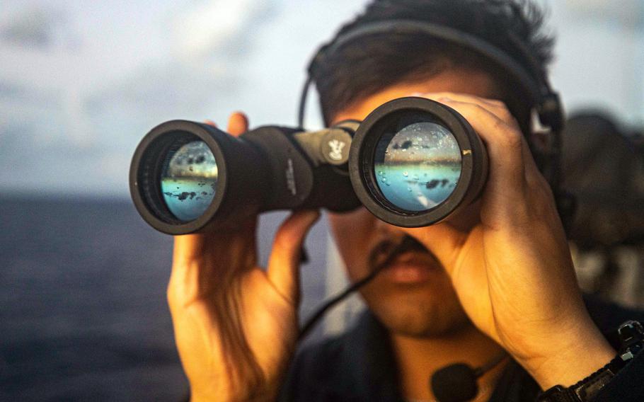 Seaman Robert Torres of Orlando, Fla., scans for surface contacts as the guided-missile cruiser USS Chancellorsville sails through the South China Sea, Tuesday, Nov. 29, 2022.