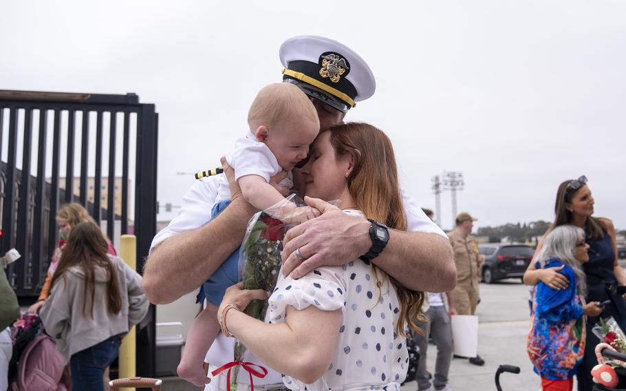 A sailor embraces his family.