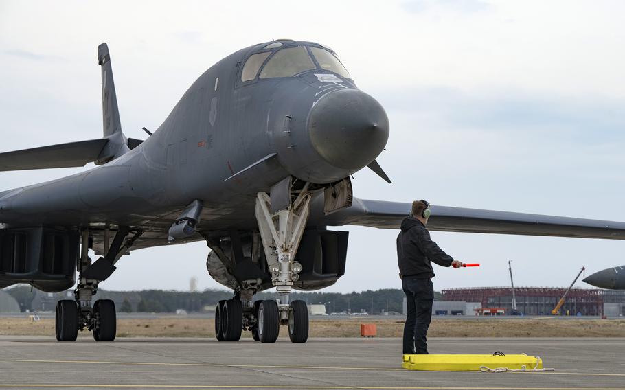 A man guides an aircraft on a base in Japan.