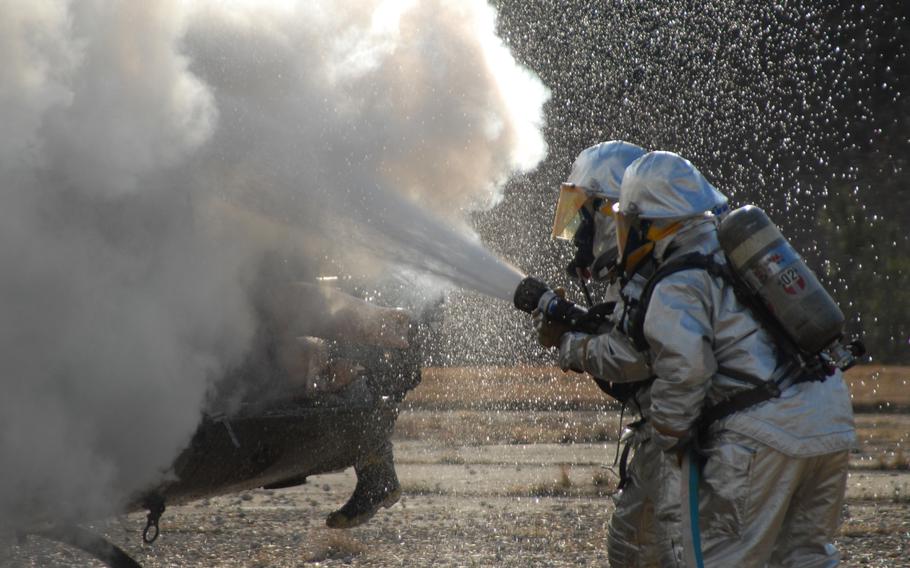 Firefighters use extinguish a helicopter fire during a training exercise in 2007. PFAS chemicals are used in everything from specialized firefighting foams on military bases and airports to consumer products such as nonstick cookware and water-repellent fabrics.