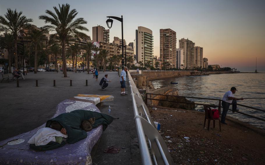 A homeless Lebanese woman and her cat sleep on a bench as the sun rises over the Mediterranean Sea in Beirut, Lebanon, on June 18, 2021. The World Bank has approved a $300 million additional financing to the poor in Lebanon in which families that live in poverty will get cash payments to help them through the country’s historic economic meltdown, the World Bank said in a statement released Friday, May 26, 2023. 