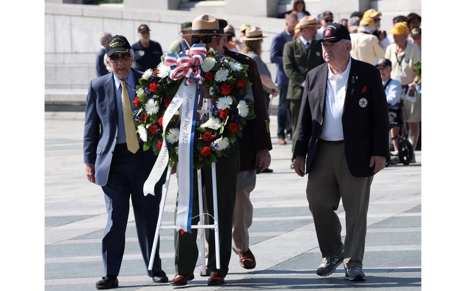World War II Merchant Marine veteran Dave Yoho, left, and Gold Star Family member Robert H. Meek Jr., right, prepare to place a wreath during a Memorial Day ceremony at the National World War II Memorial in Washington, May 30, 2022. Meek’s father, a B-25 crew member, was killed on a mission over Italy in October 1944.