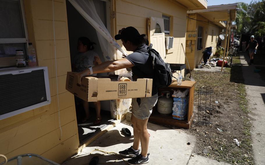 Volunteers and staff members with Better Together, a nonprofit organization based in Naples, Fla., deliver food and toiletries for families in the Harlem Heights neighborhood in Fort Myers on Oct. 4. 