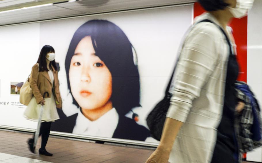 Commuters walk past photos of Megumi Yokota, who was abducted by North Korea in 1977, at Shinjuku Station in Tokyo, May 9, 2018.