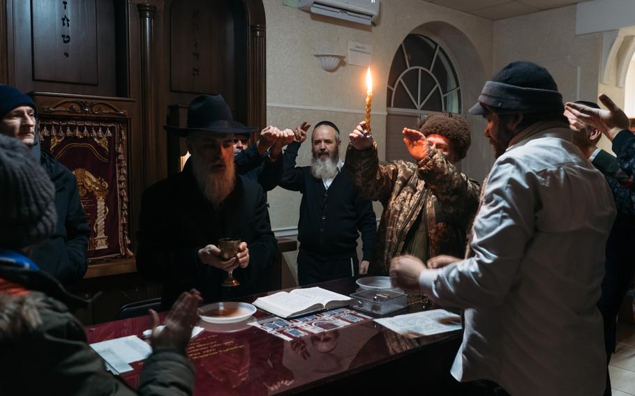 Rabbi David Goldich blesses the wine during sabbaths prayer at the Great Choral Synagogue office used instead of the main building due to power outages in Kyiv, Ukraine, on Dec. 10, 2022. 