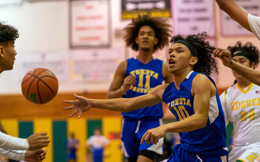 Yokota's Royce Canta dishes a no-look pass against Robert D. Edgren during Friday's DODEA-Japan boys basketball game. The Panthers won 71-31.