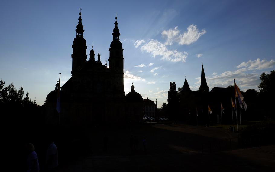 Fulda’s Baroque basilica, left, and St. Michael’s Church are silhouetted in the setting sun. The former was built in the early 18th century, while the latter is 900 years older.