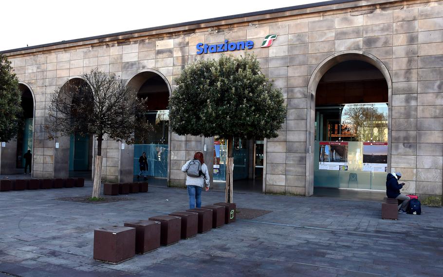 The person carrying a backpack walks into the train station in Vicenza, Italy.