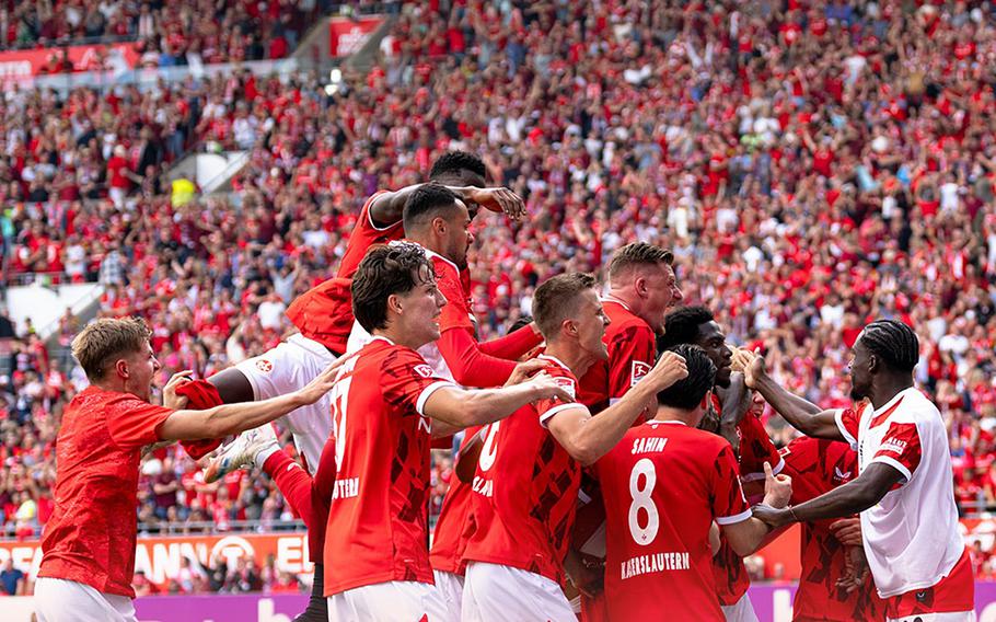 soccer players in red jerseys celebrating
