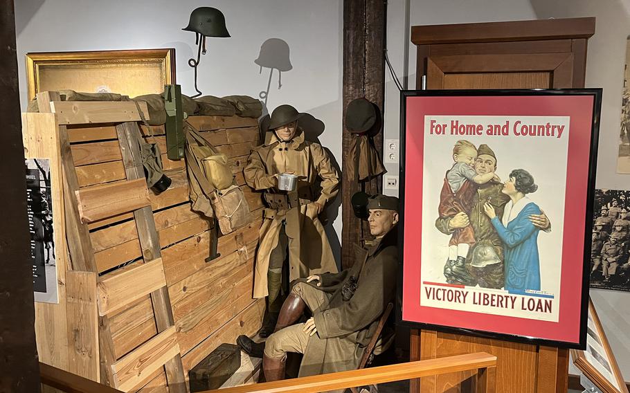Military uniforms are on display in a museum.