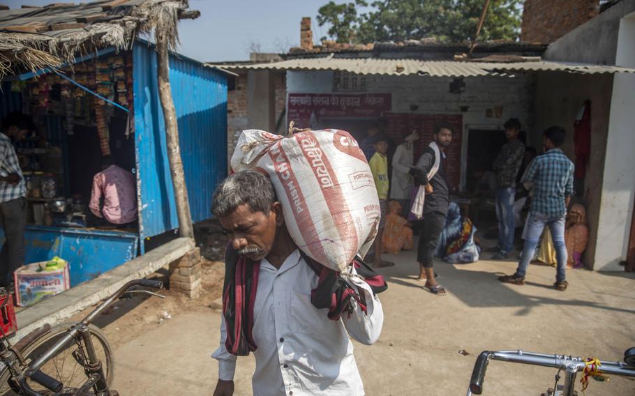 A man carries a sack of food at a state-run ration store in Banda District, Uttar Pradesh, India, on Oct. 12, 2020.