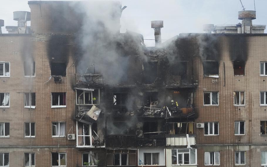 A building with smoke bellowing from where it was attacked.
