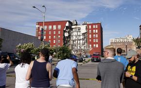 Onlookers watch as emergency crews work the scene of a partial building collapse on the 300 block of West Third Street, Sunday, May 28, 2023, in Davenport, Iowa. 