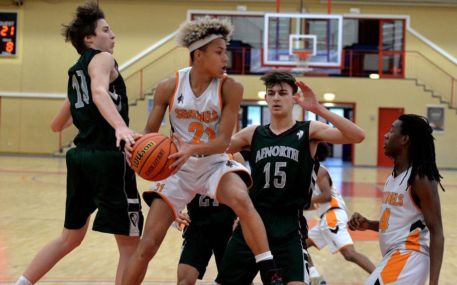 Spangdahlem’s Cameron Lewis pulls down a rebound in front of AFNORTH’s Emile Masse, left, and Nathan Goldsmith in a Division III game at the DODEA-Europe basketball championships in Baumholder, Germany, Feb. 16, 2023. The Sentinels beat the Lions 51-45.