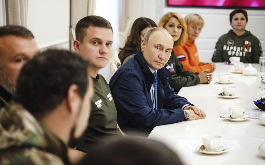 Russian President Vladimir Putin speaks with volunteers