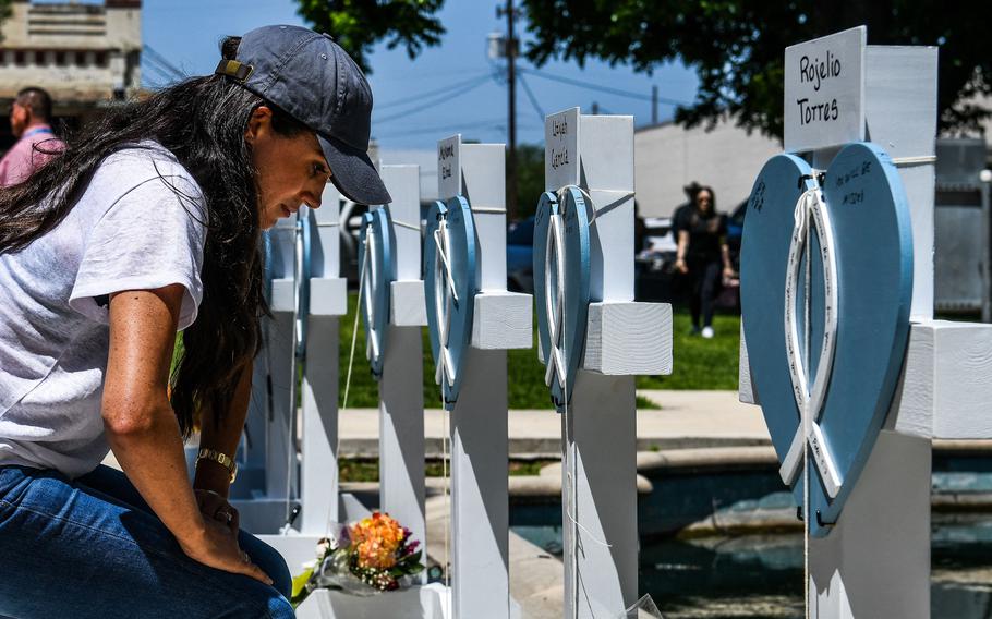 Meghan, Duchess of Sussex, places flowers as she mourns at a makeshift memorial outside Uvalde County Courthouse in Uvalde, Texas, on May 26, 2022.