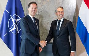 Two men shake hands.
