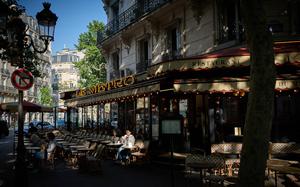 A patron reads at a table on the terrace of "Le Metro" cafe restaurant in the morning sunshine in central Paris, on May 14, 2025. (Kiran Ridley/AFP/Getty Images/TNS)