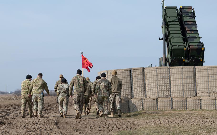 Members of Delta Battery walk on March 7, 2023, in southeast Poland, with a streamer they were awarded in February for being the best Patriot crew of the Army’s 5th Battalion, 7th Air Defense Artillery Regiment.