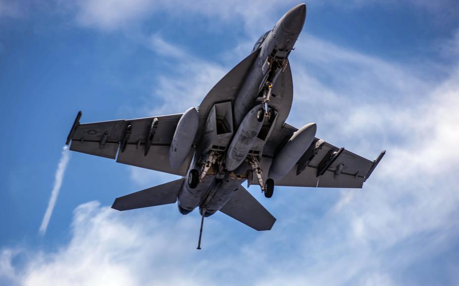 In a May 28, 2021 photo, an F/A-18F Super Hornet attached to the Diamondbacks of Strike Fighter Squadron 102 flies over the flight deck of the USS Ronald Reagan.