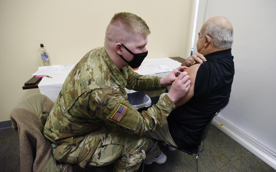 FILE - Private David Philo, with the Michigan National Guard, administers a COVID-19 vaccine dose to Norman Pizzotti during a vaccination clinic held Saturday, Jan. 16, 2021, at the Berrien County Health Department in Benton Harbor, Mich. A third 22-member medical team from the U.S. military is being deployed to Michigan, where hospitals are grappling with record-high COVID-19 patients amid the state's fourth surge of infections. The nurses, doctors and respiratory therapists will assist Covenant Healthcare in Saginaw starting Dec. 12, the state health department said Thursday, Dec. 2, 2021. (Don Campbell/The Herald-Palladium via AP, File)