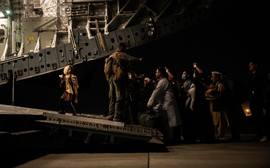 An Afghan child walks up the ramp of a U.S. Air Force C-17 Globemaster III at Hamid Karzai International Airport in Kabul, Afghanistan, during Operation Allies Refuge, Aug. 19, 2021. 