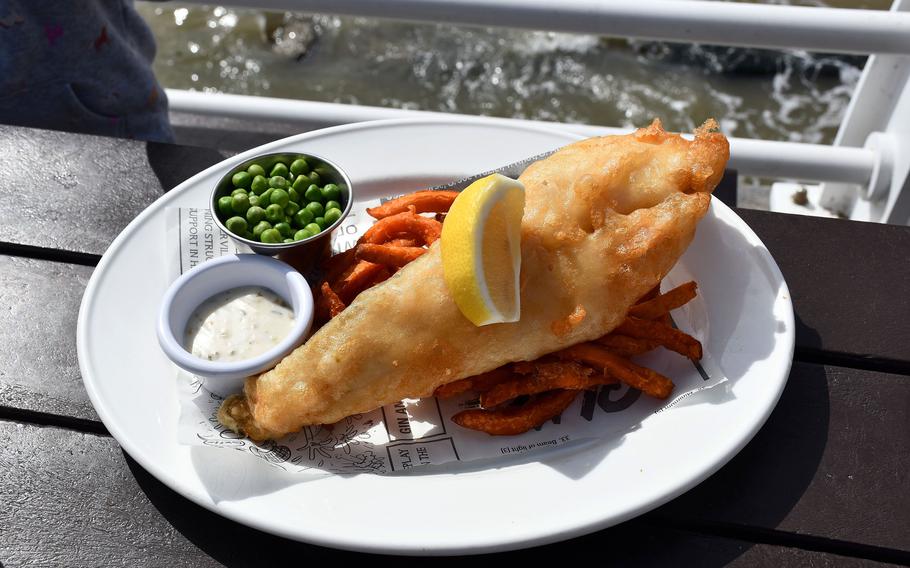 The beer-battered fish rests on a bed of sweet potato fries near a side of peas at the Boardwalk Cafe Bar on the Felixstowe Pier in Felixstowe, England.