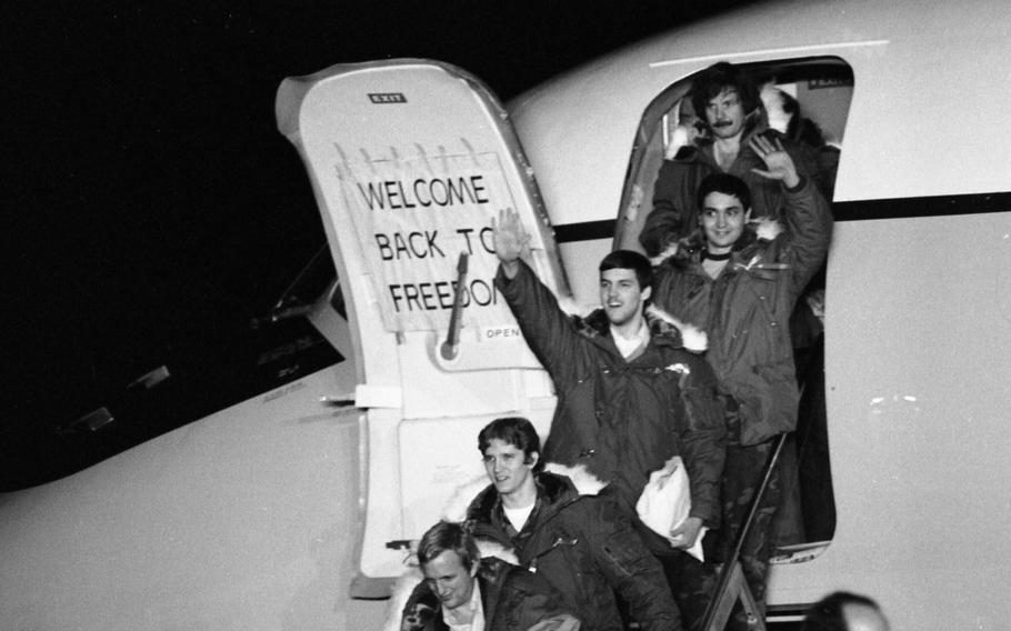 Hostages wave as they emerge to cheers as they step out of one of the two C-9 planes.