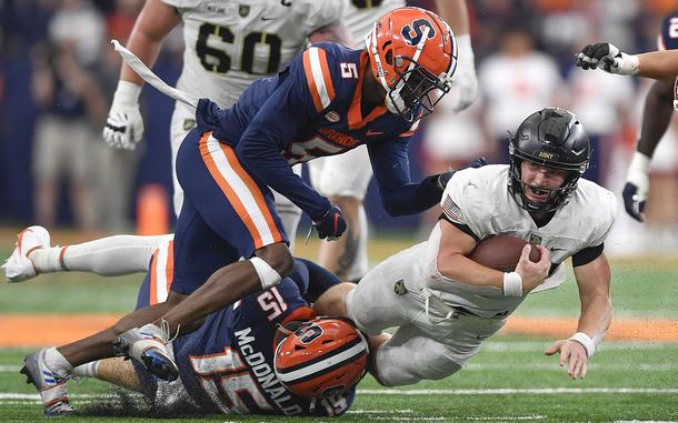 Army quarterback Bryson Daily dives forward as he's tackled by Syracuse linebacker Derek McDonald, left, and defensive back Alijah Clark during the first half of an NCAA college football game in Syracuse, N.Y., Saturday, Sept. 23, 2023.