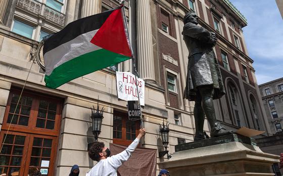 Pro-Palestinian student protestors wave a Palestinian flag as they gather on the front steps of Hamilton Hall at Columbia University in New York City on April 30, 2024. Columbia University normally teems with students, but a "Free Palestine" banner now hangs from a building where young protesters have barricaded themselves and the few wandering through campus generally appear tense. Students here were among the first to embrace the pro-Palestinian campus encampment movement, which has spread to a number of universities across the United States. (Emily Byrski/AFP/Getty Images/TNS)