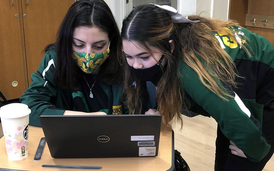 Jasmine Vina, left, and Haley Black, wearing face masks at Edgren Middle/High School on Misawa Air Base, Japan in November 2020. Masks will be required indoors at Defense Department schools this fall, including for students and teachers who are already vaccinated against the coronavirus, school and military officials said.