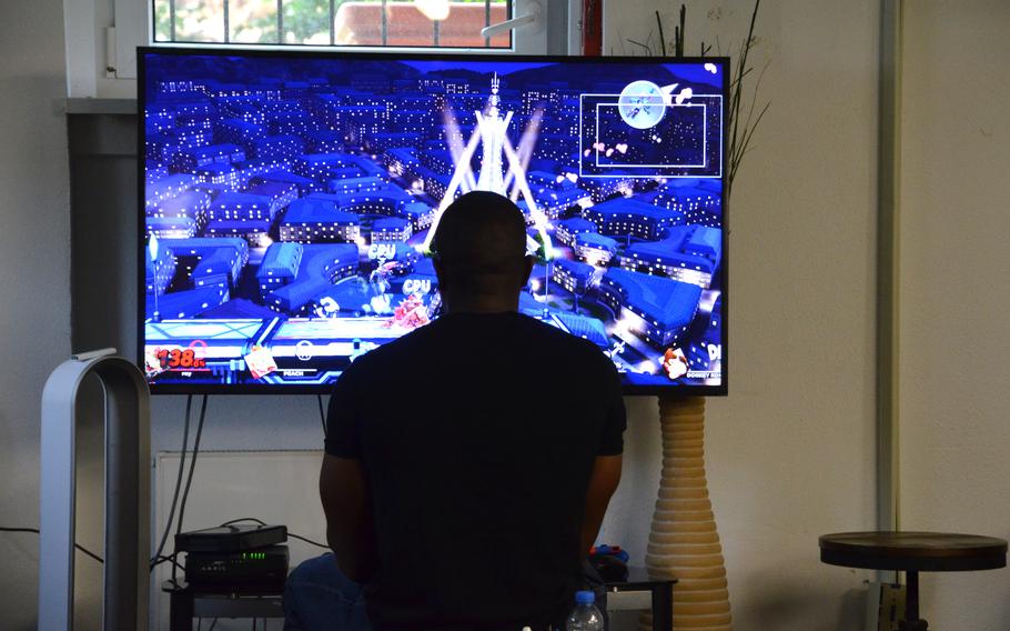 A service member returning from an overseas deployment plays a video game in the lounge of the Deployment Transition Center at Ramstein Air Base, Germany, June 25, 2021. 