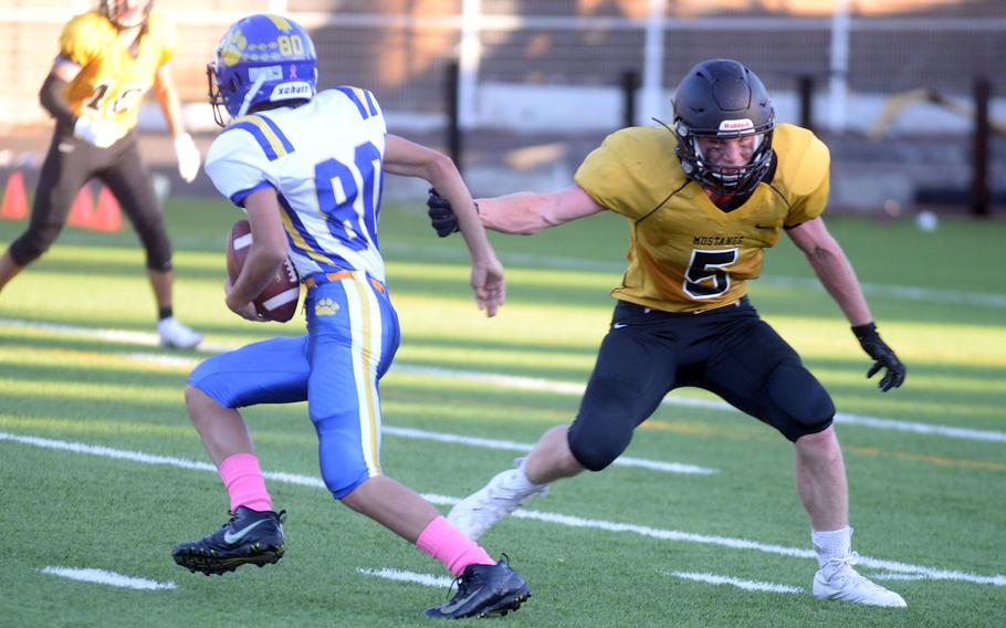 Yokota receiver Royce Canta slips past American School In Japan defender Pierce Smith with the ball.