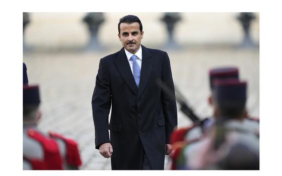 Qatar's Emir Sheikh Tamim bin Hamad Al Thani reviews French troops in the courtyard of the Hotel des Invalides in Paris on Tuesday, Feb. 27, 2024. 