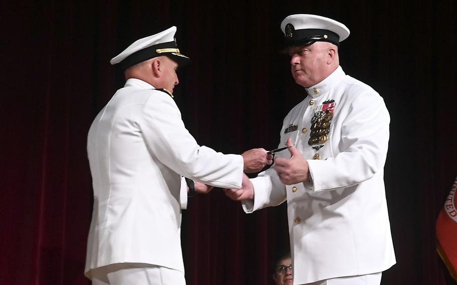 Chief of Naval Operations Adm. Mike Gilday hands the Master Chief Petty Officer of the Navy cutlass to MCPON James Honea during a ceremony at the U.S. Naval Academy, Sept. 8, 2022.